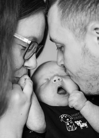 Deux parents faisant un bisou à leur bébé