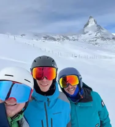 Group of friends taking a selfie with the iconic Matterhorn mountain background during a guided ski 