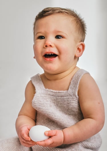 a baby is smiling and holding a white object