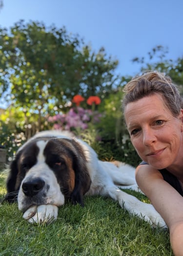 Hund und Mensch auf einer Wiese liegend