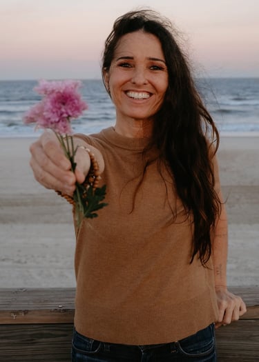 Michael Alexa Pitts Consciousness Advocate at the beach near sunset & offering you a handful of lavender flowers