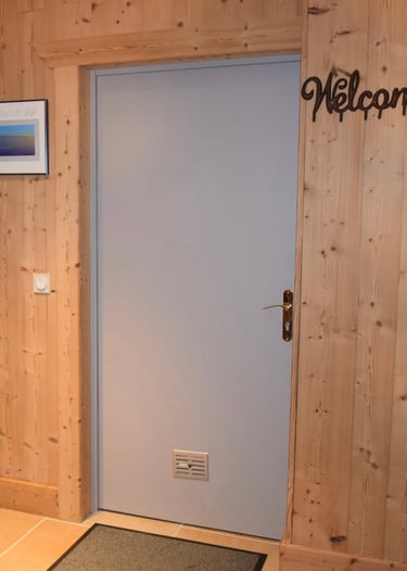 Porte de service grise avant réalisation du décor peint. Boiseries aux murs.