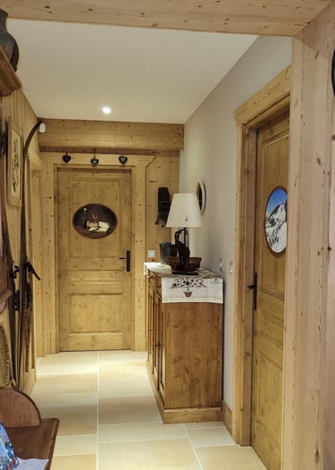 Intérieur d'un chalet dont les portes sont décorées de médaillons en trompe-l'oeil, thème jurassien.