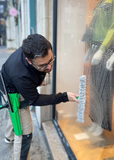 Technicien de M & M Services Pro nettoyant la vitrine du magasin Léo et Ugo à Rouen