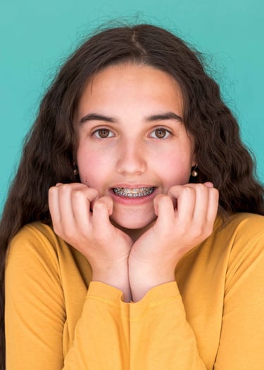 little girl in front smiling with braces