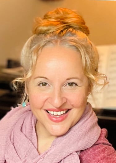 eine Frau - Sina Weidlich - mit Hochgestecken blonden Haaren und einem rosé-farbenen Schal.