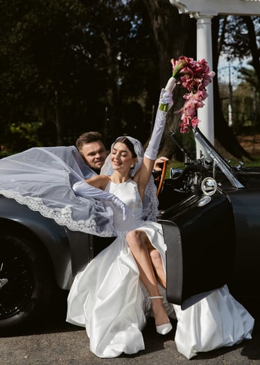 Woman and a man sitting in a 1958 MG MGA Roadster at Tulu Vineyards in Galt, Ca.