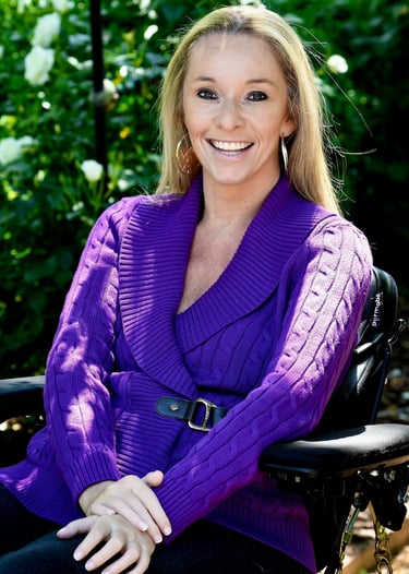 Headshot of Ali Ingersol shows her in a purple blouse in a scenic setting