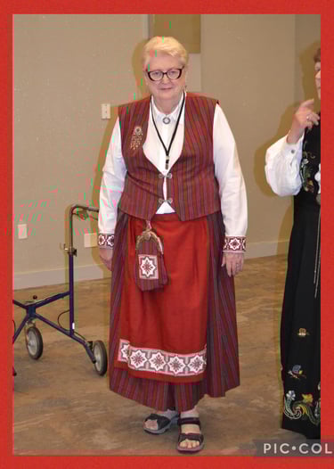 a woman with glasses in red festdrakt