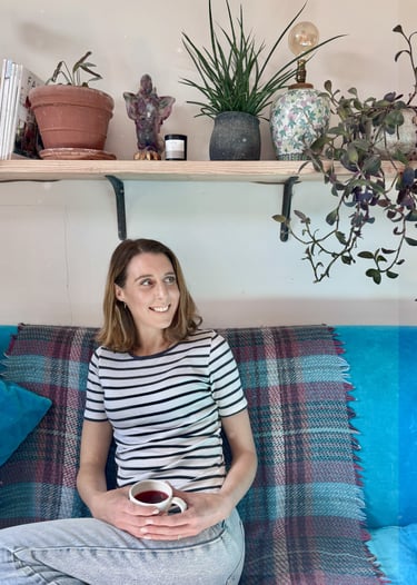 a woman sitting on a couch with a cup of coffee