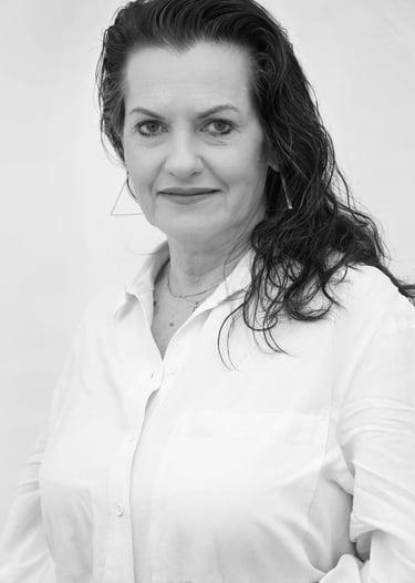 Professional black and white portrait of a woman with dark wavy hair in a white button-down shirt.