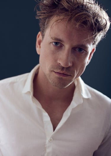 A portrait of a young man in a white shirt.