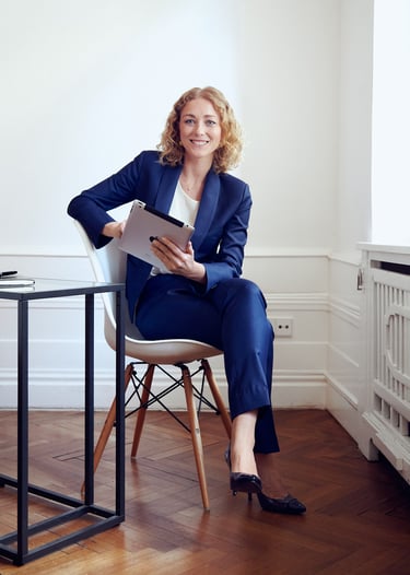 Woman holding an ipad sitting in an office.