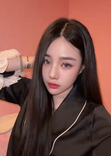 KL Escort Young Asian woman with long straight black hair and makeup posing in black pajamas.
