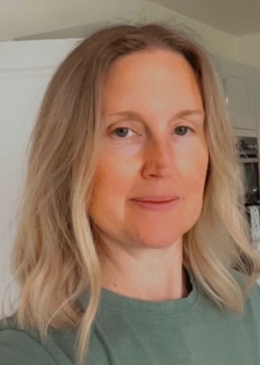 Profile of a middle aged woman with short blonde hair wearing a green t-shirt