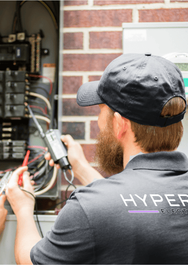 A Hyperion electrician checking an electrical service panel with a journeyman in training 