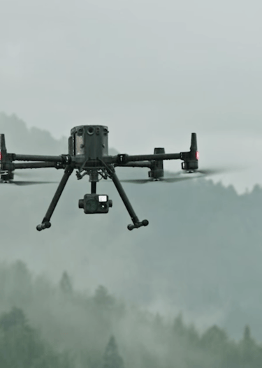 a small drone flying over a mountain range