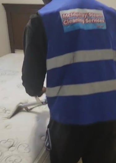 Technician steam cleaning bed in Fort McMurray home.