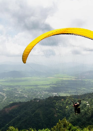 Paragliding over Jarabacoa Dominican Republic with panoramic mountain views and green valleys
