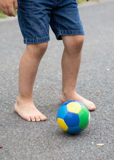 Close-up of a young boy smiling proudly in his football uniform during practice.