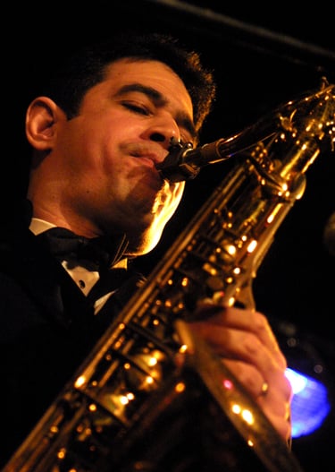 Maestro Bobby Ramirez in a tuxedo playing a saxophone