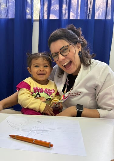 a woman in glasses and a white shirt is smiling and holding a child