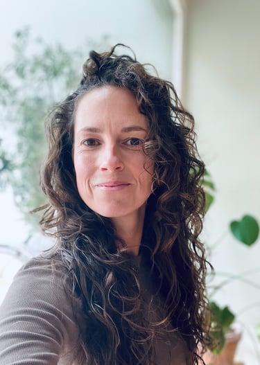 a woman with long hair and a brown sweater