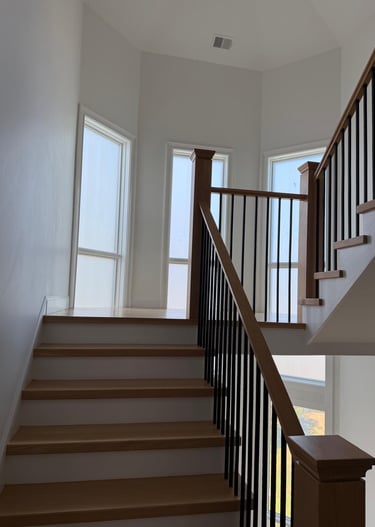 Interior staircase with glass railing and natural light