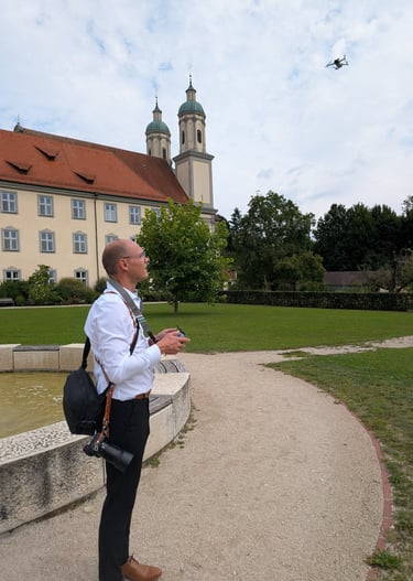 a man standing in front of a building and flying a drone dji