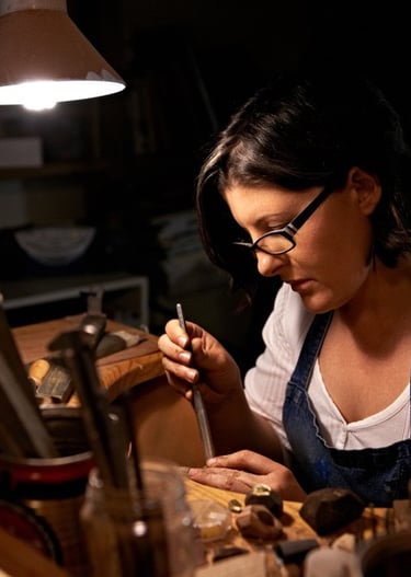 Artesana joyera trabajando con herramientas metálicas para la elaboración de joyería.