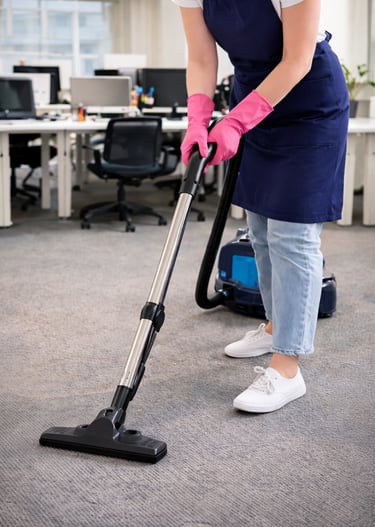 professional office cleaning service vacuuming carpet in workspace