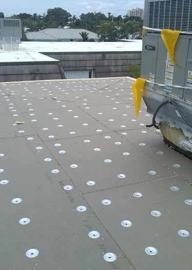 Inst of tapered insulation secured with screws and plates ready for mid plies and cap sheet