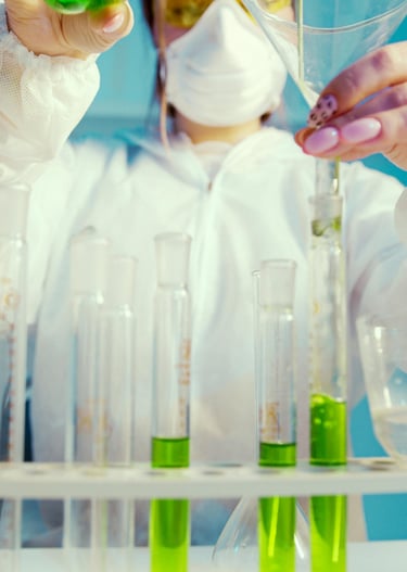 a person in a lab coat is pouring liquid into a beaker