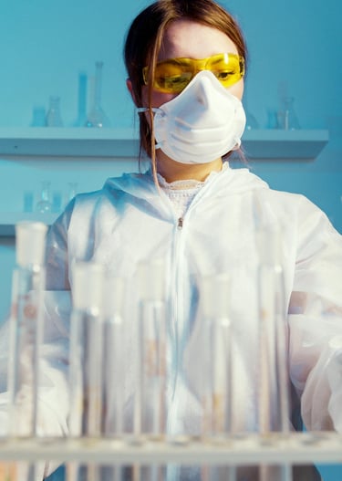 a woman in a lab coat and goggles with a mask on