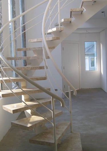 Escada interna com degraus de concreto, faixas antiderrapantes e corrimão de alumínio em ambos os lados para acessibilidade, 