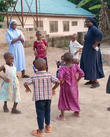 Catholic nuns play outdoor games with local children at an African community center.