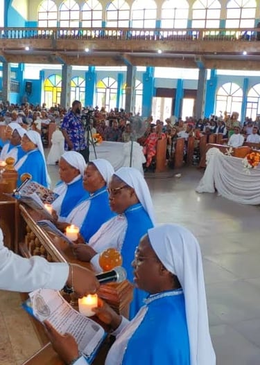 Catholic nuns in blue habits holding lit candles during a church ceremony with a congregation present.
