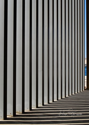 a long line of columns with a sky background