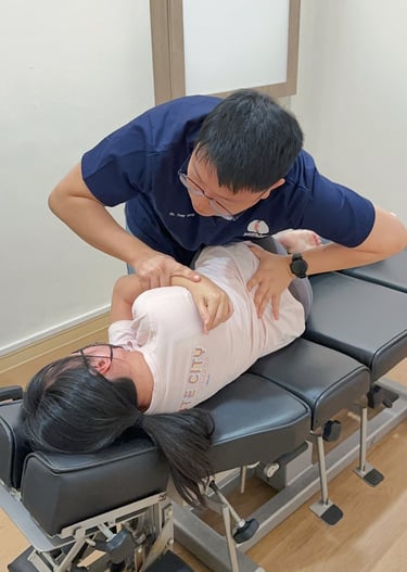  Chiropractor adjusting patient's spine during chiropractic session at Sinisana Chiropractic clinic.