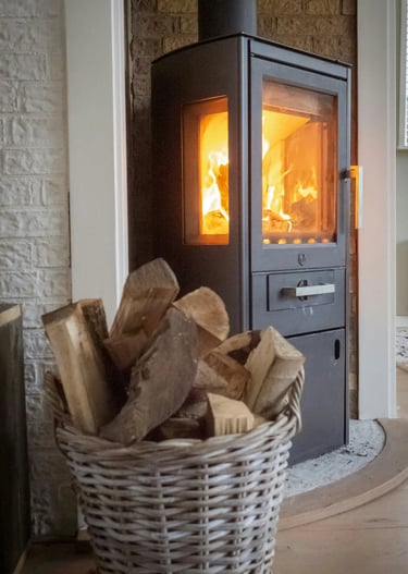Image of a roaring fireplace with a basket of wood in front