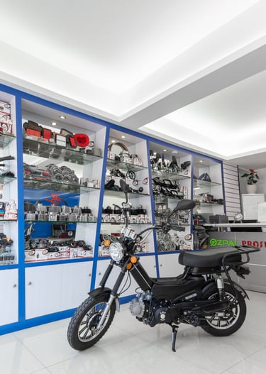 A modern motorcycle lights store featuring a moped and glass shelves stocked with spare accessories.