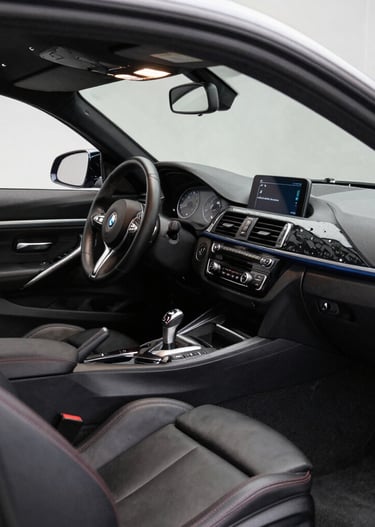 Close-up of a polished steering wheel and dashboard of a high-end vehicle with ambient lighting.