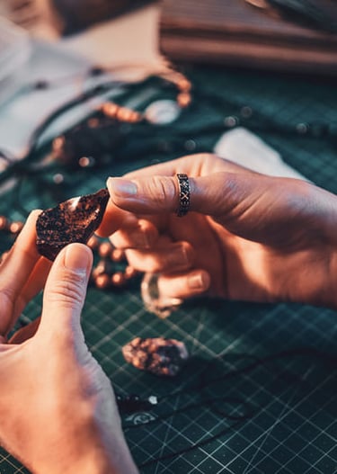 manos de mujer tomando una piedra natural ojo de tigre
