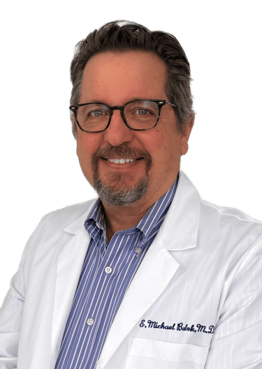 man wearing glasses in a white coat and dress shirt