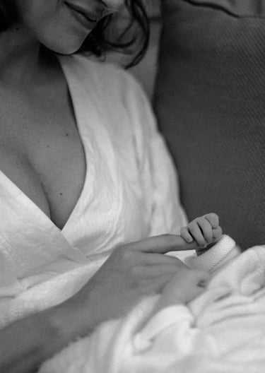 newborn baby holding mothers index finger tight in a lifestyle newborn photography session
