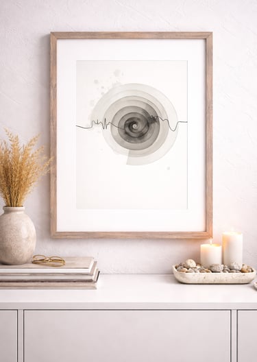 Framed minimalist abstract spiral art print on a white sideboard with candles and dried pampas grass.