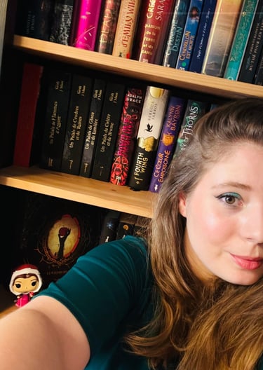 Mandy, créatrice de Révéria, devant sa bibliothèque remplie de romans