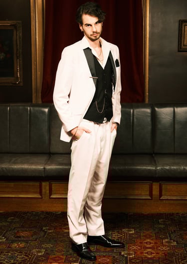 a man in a white suit and black tie