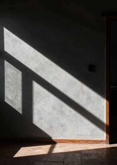 Enigmatic photograph of a room in a South American / Argentine house where sunlight creates sharp geometric shapes against Deep charcoal shadows.