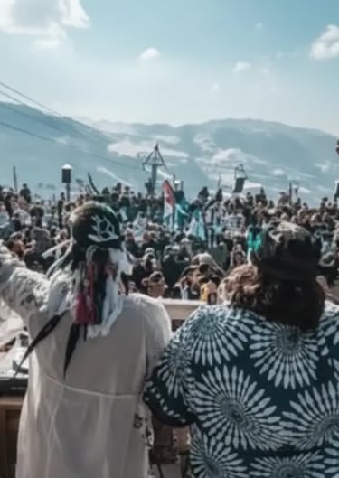 Outdoor winter music festival and crowd atmosphere at a mountain lodge.